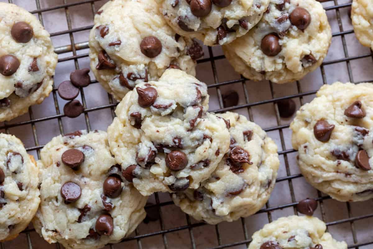 pile of cream cheese chocolate chip cookies on a wire rack.