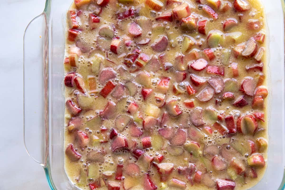 rhubarb pieces in an unbaked yellow custard in a glass dish.