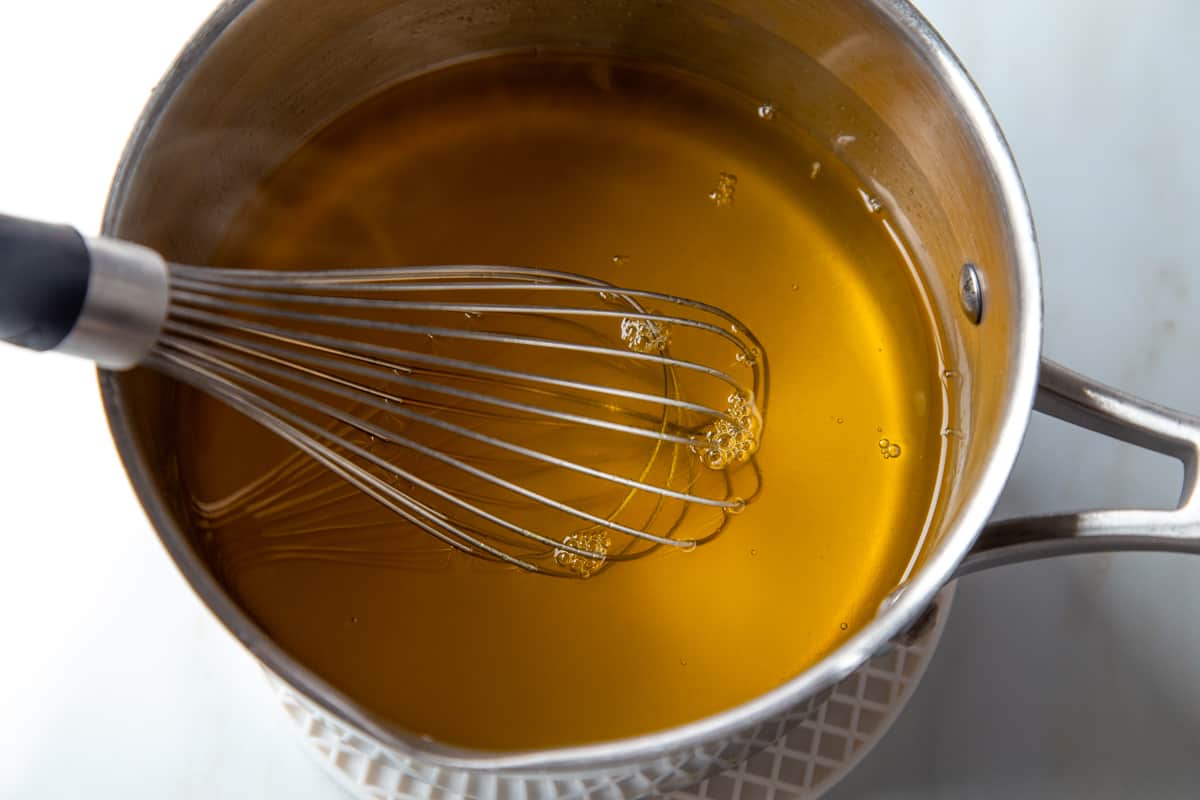 lemon gelatin liquid in a saucepan with a whisk.