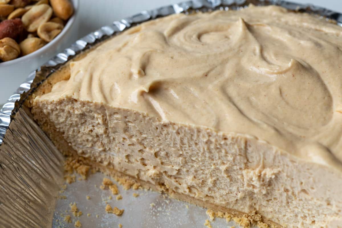 half of an old fashioned peanut butter pie in a foil pie dish.
