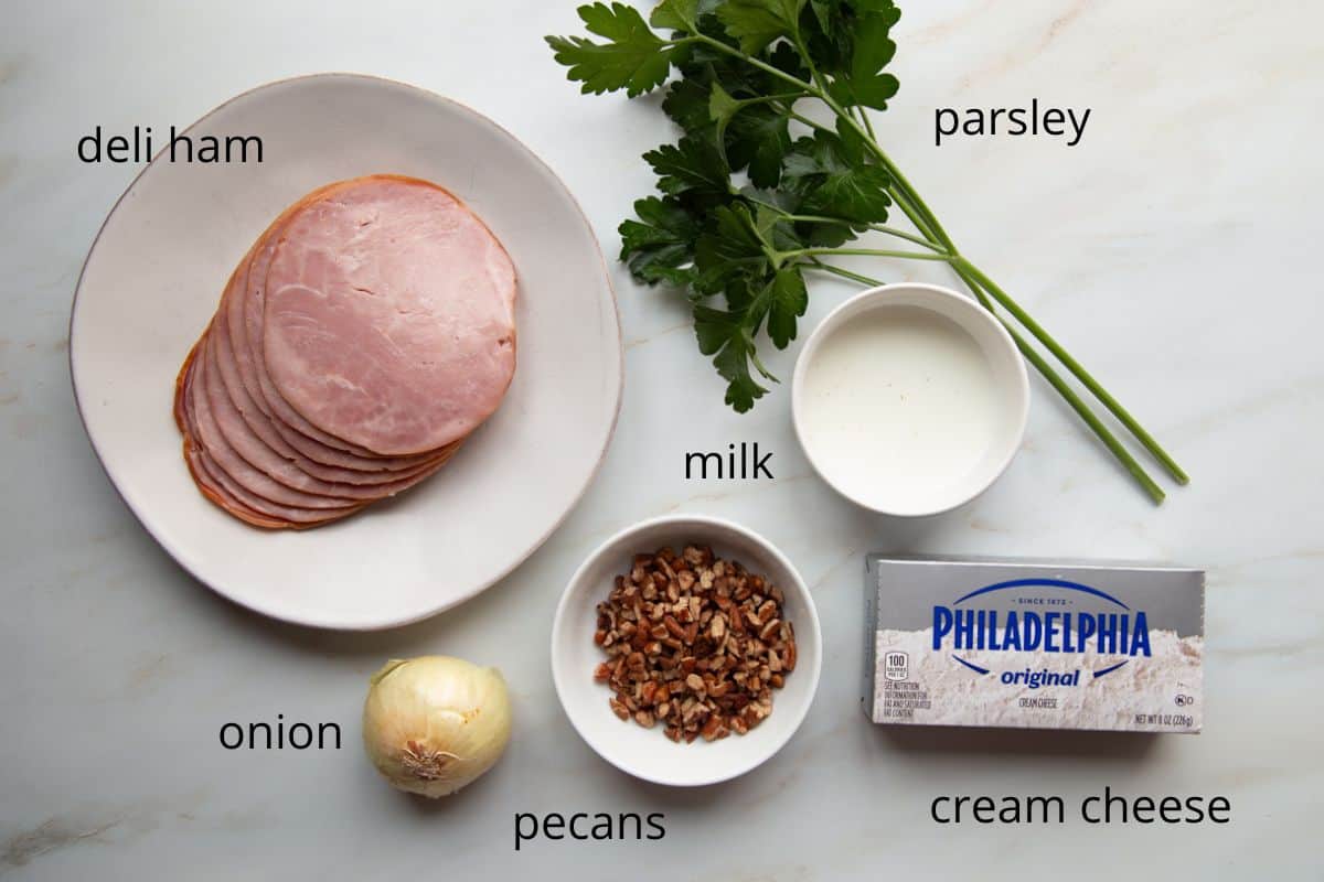 ham, cream cheese, pecans, and other ingredients on a white table.