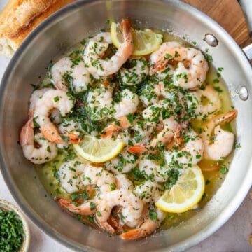 shrimp scampi with lemon slices in a skillet.