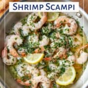 shrimp scampi with lemon slices in a metal skillet.