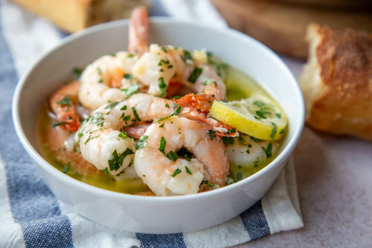 shrimp scampi in a small round white dish.