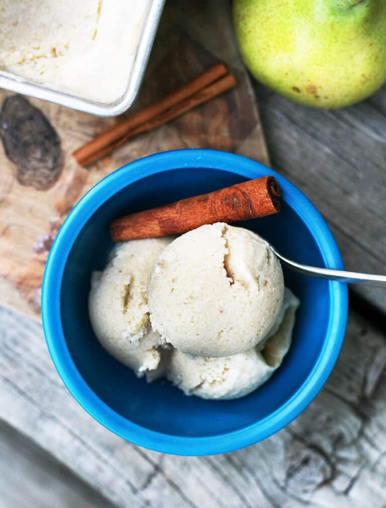 Top view of a small blue bowl full of Homemade Pear Ice Cream and a cinnamon stick.