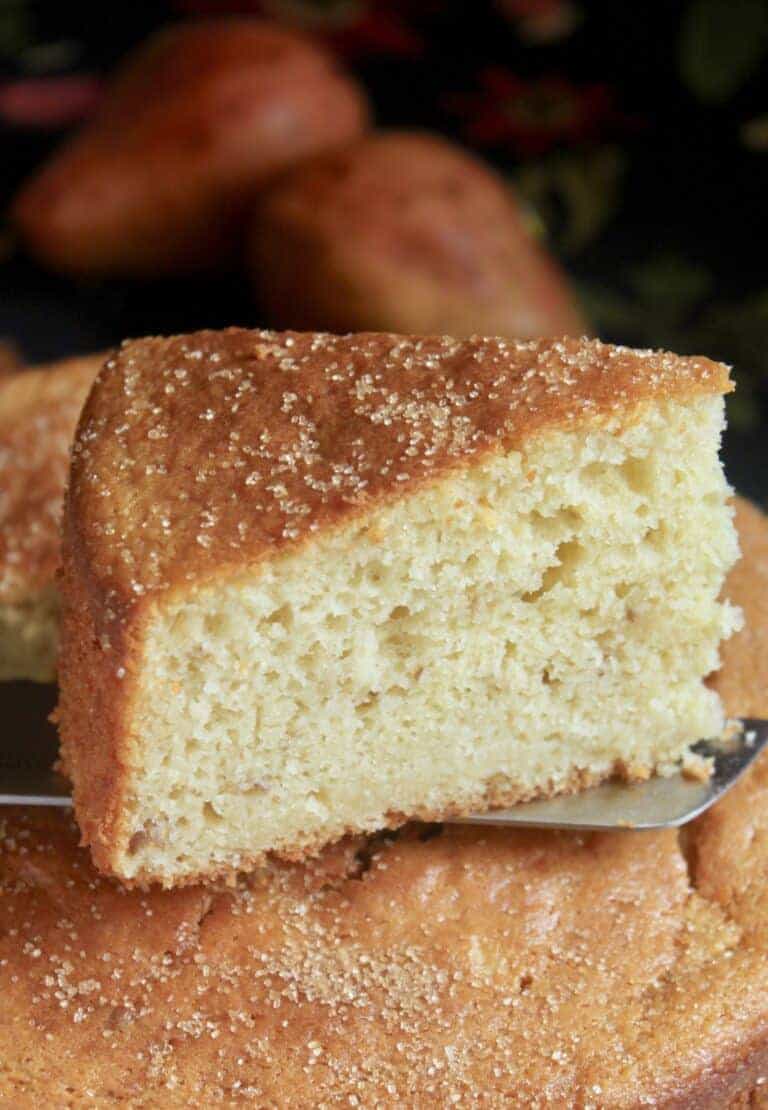 A slice of Pear Cake sprinkled with cinnamon sugar on a metal spatula.