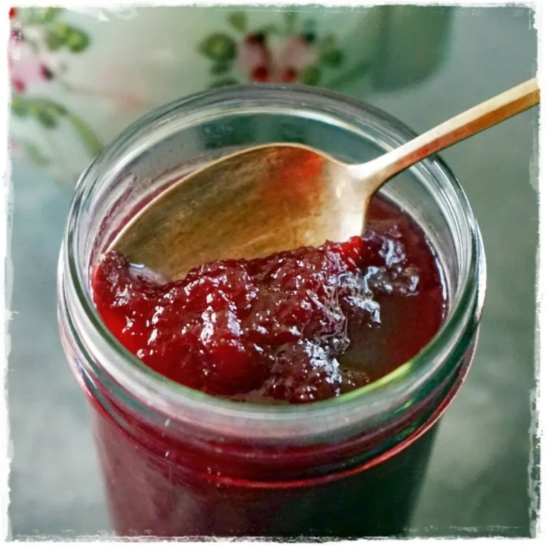 Top view of Poached Pear Jam in a mason jar with a spoon inserted.