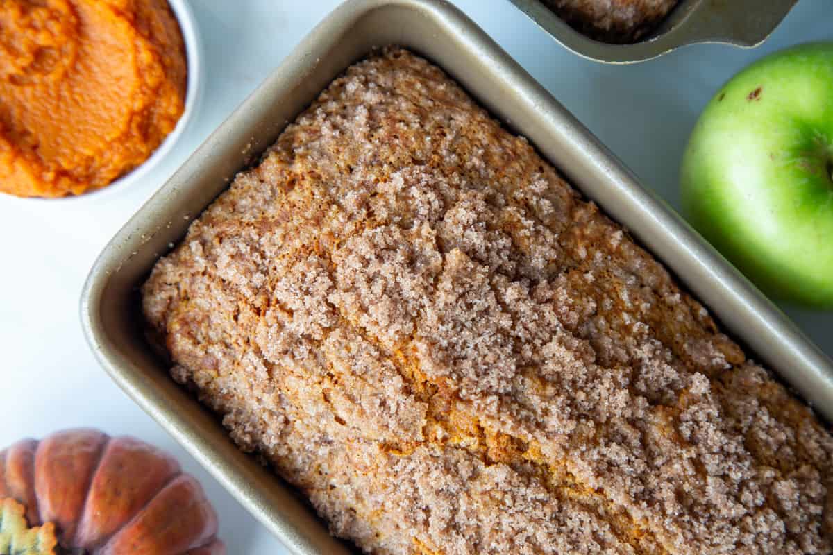 loaf of pumpkin apple bread in a loaf pan.