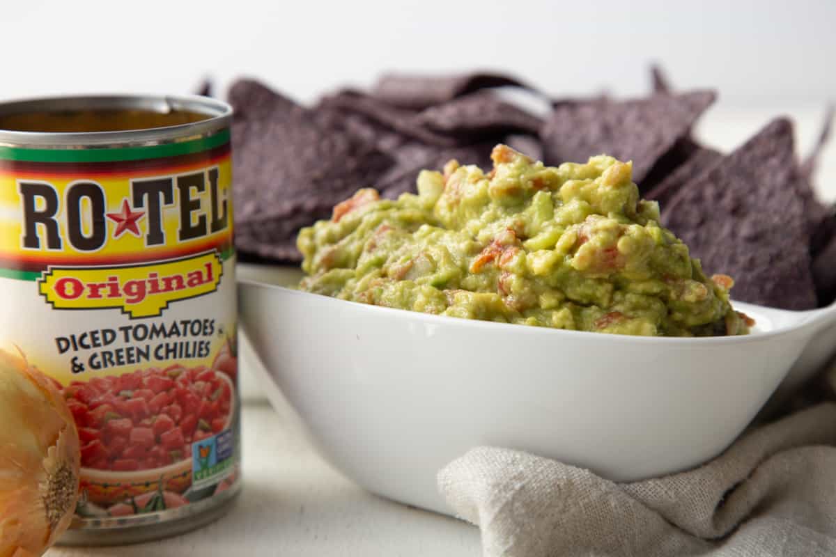 A can of Rotel next to a white container Rotel Guacamole.