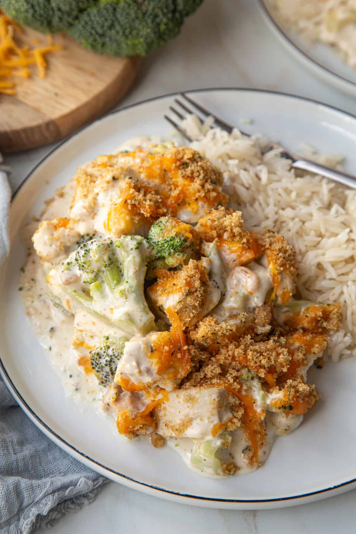 A large serving of Nixon Chicken Casserole on a white plate next to white rice.