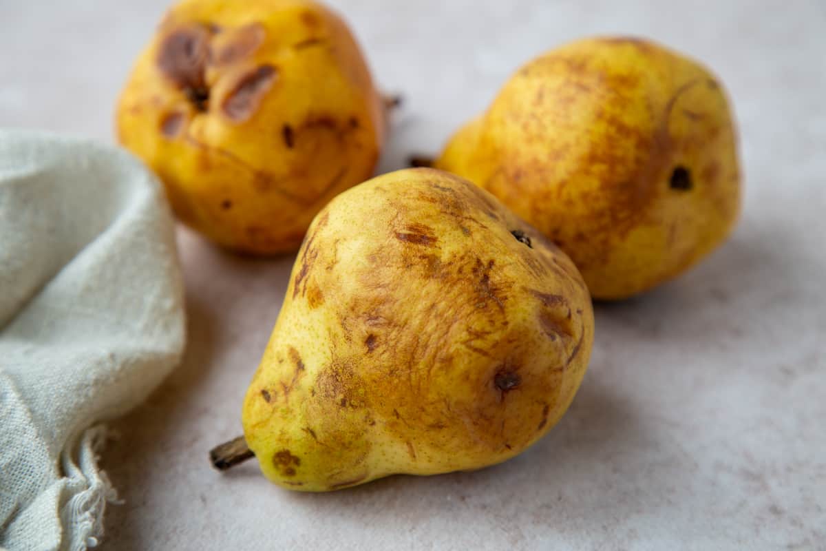 3 overripe pears with brown spots.