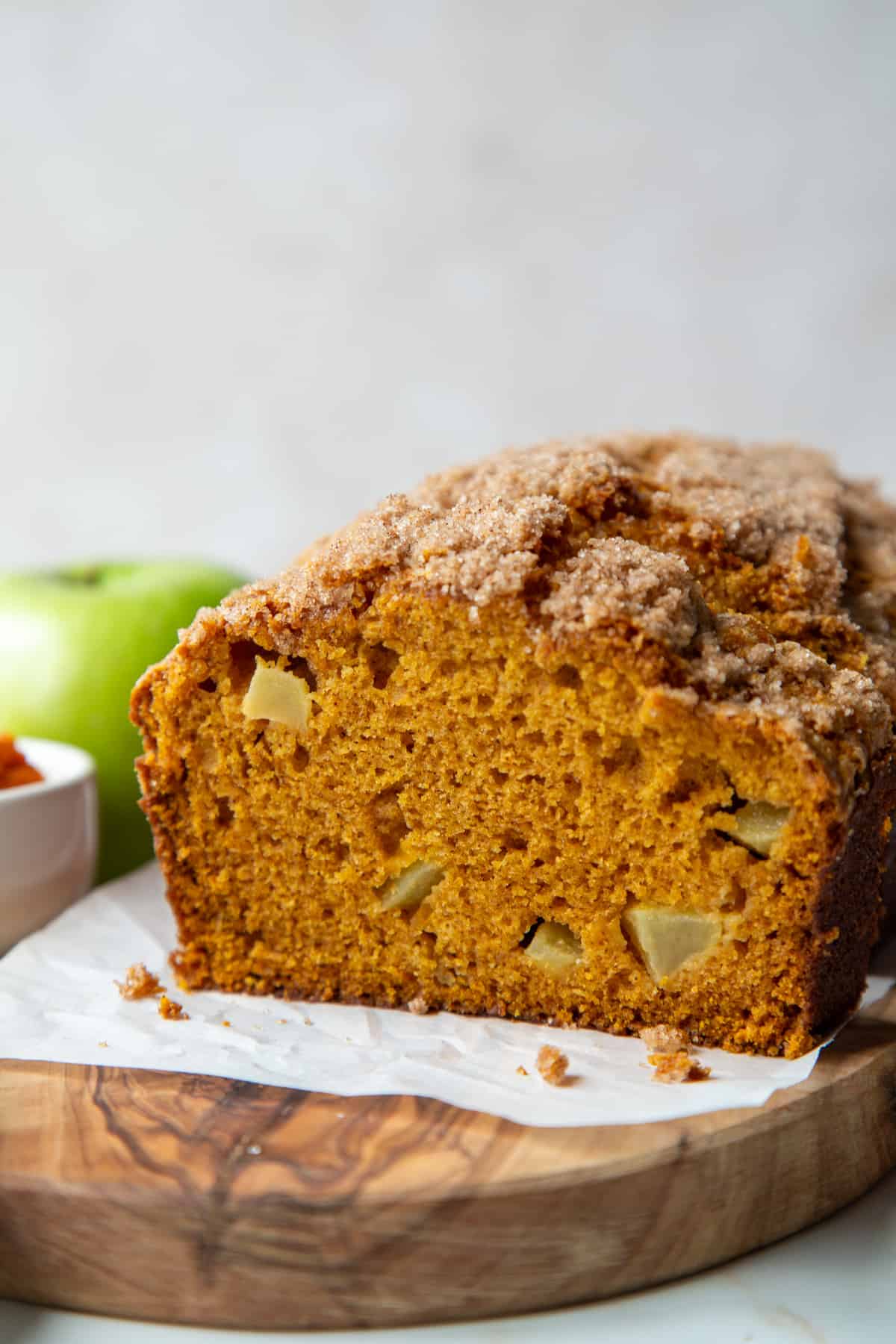 pumpkin apple bread sliced on a wooden board.