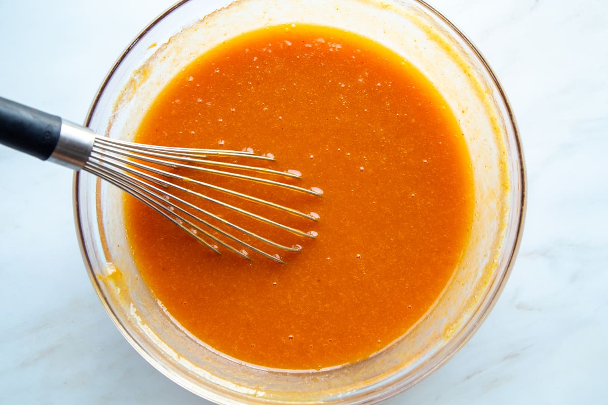 pumpkin puree mixture in a glass bowl with a whisk.