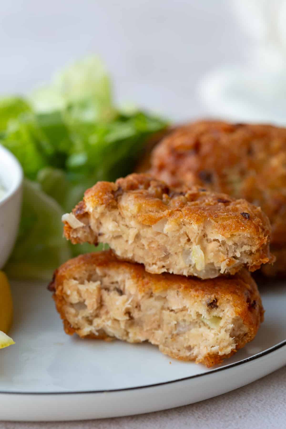 Salmon Patty cut in half and stacked on top of each other on a dinner plate.