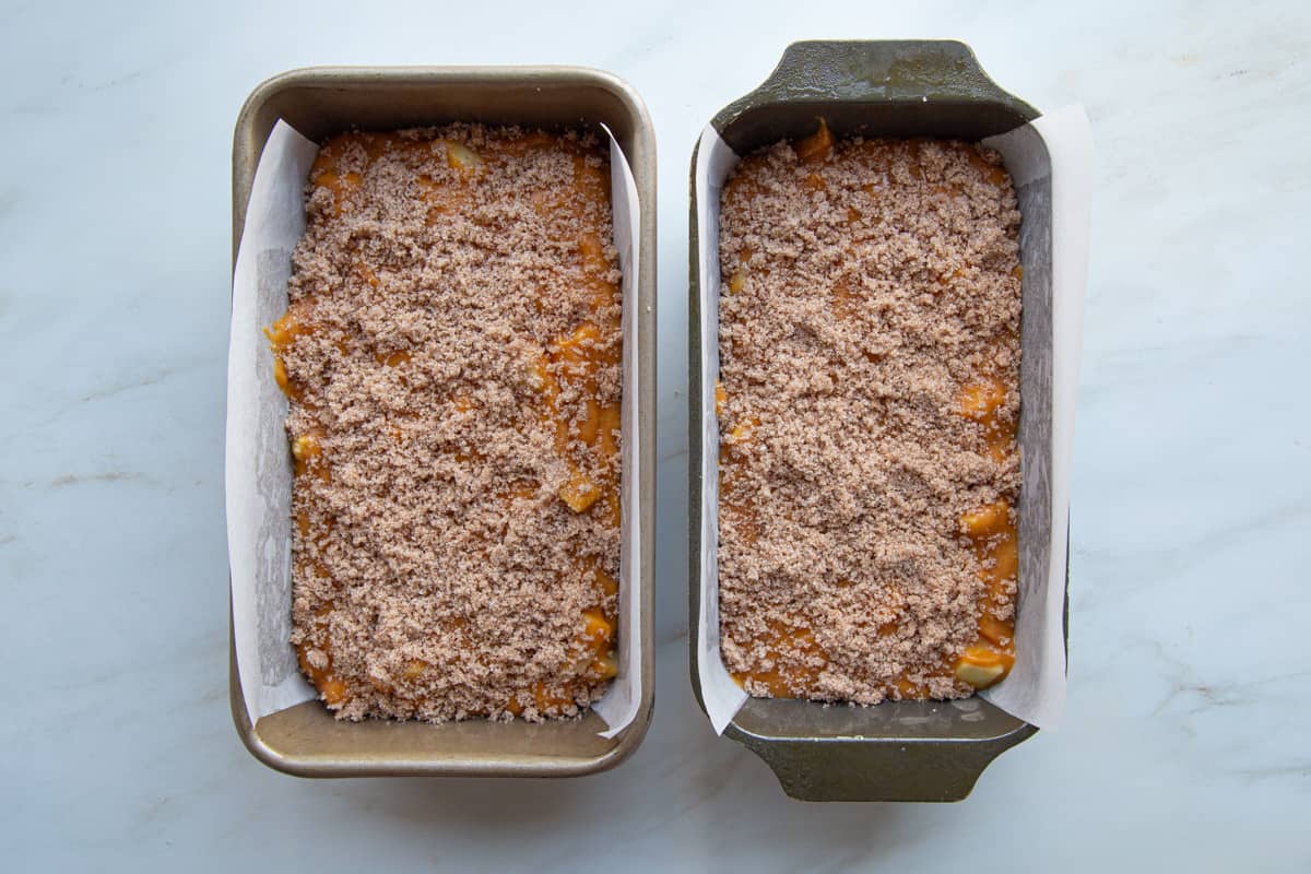 unbaked pumpkin bread in loaf pans, topped with streusel. 