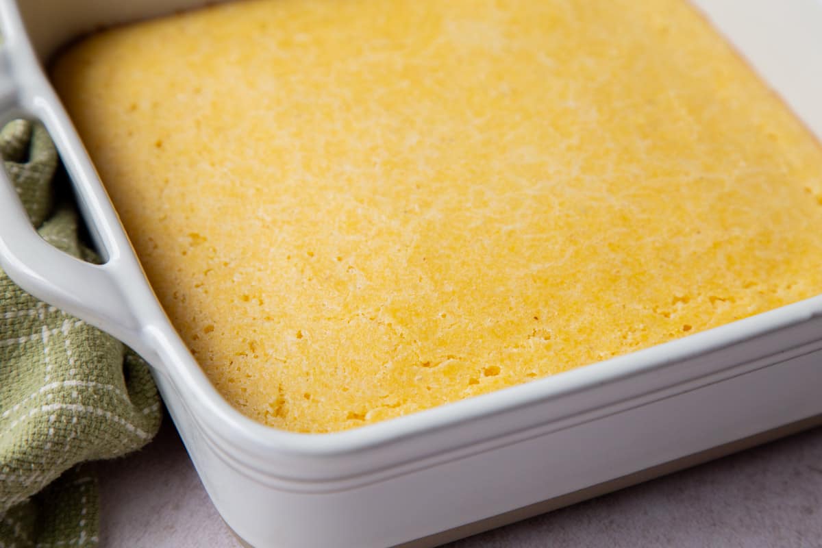 baked old fashioned cornbread in a white baking dish.