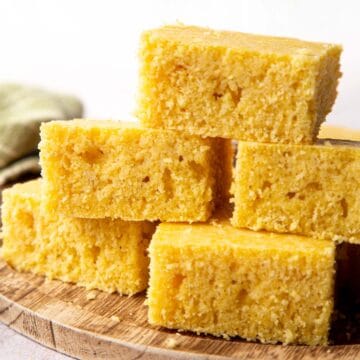 5 pieces of cornbread stacked on a wooden suface.