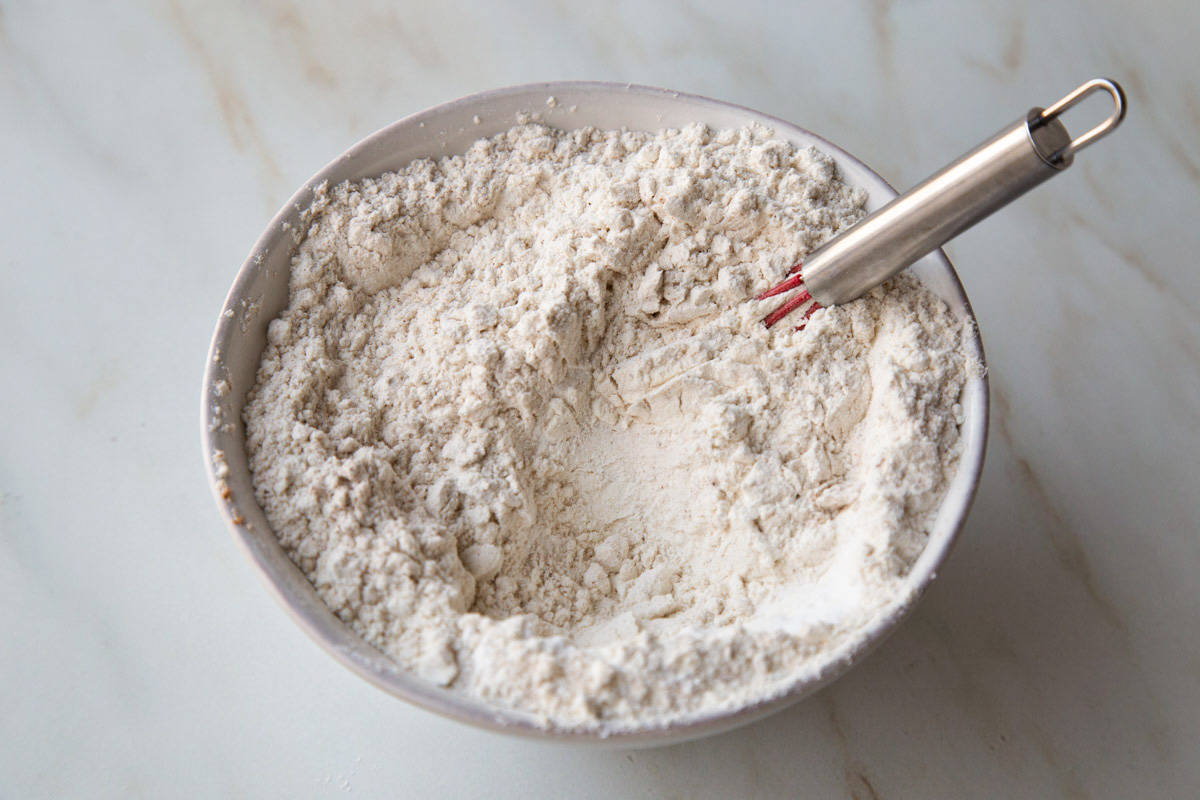 flour mixture in a white bowl with a whisk.