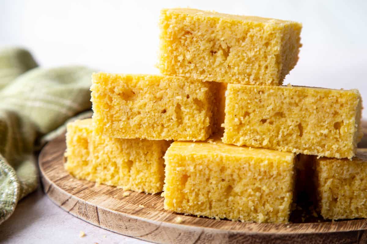 6 slices of cornbread stacked in a pyramid on a wooden surface.