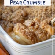 spoon lifting pear crumble from a casserole dish.