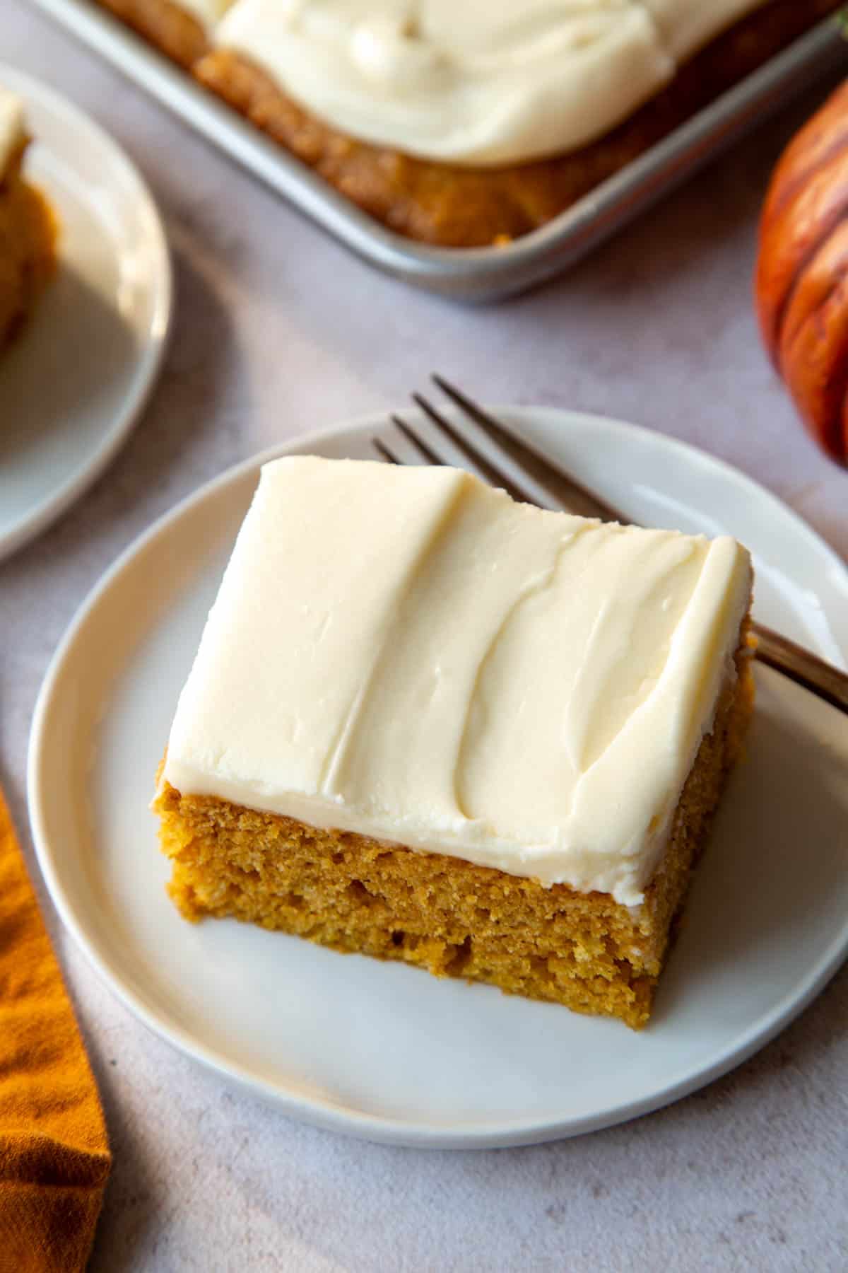 slice of Pumpkin Bar with Cream Cheese Frosting on a small white plate.