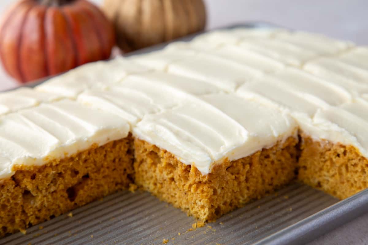 Sliced Pumpkin Bars with Cream Cheese Frosting in a metal pan.