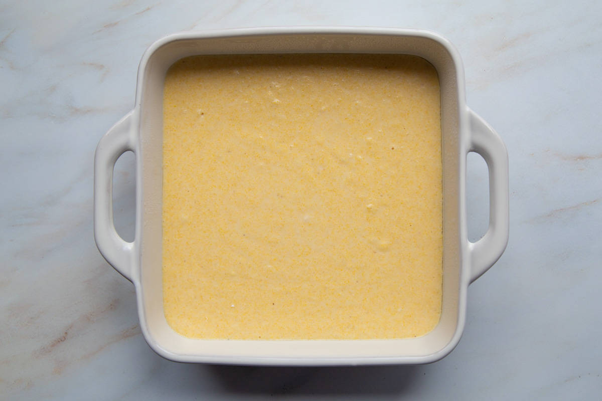 cornbread batter in a white baking dish.