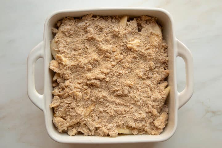 Unbaked Pear Crumble in a white ceramic baking dish.
