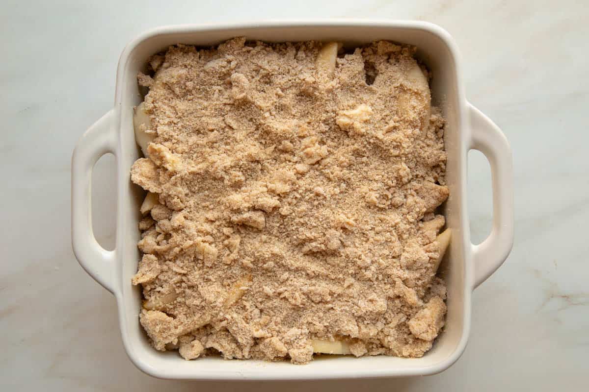 unbaked Pear Crumble in a white ceramic baking dish.