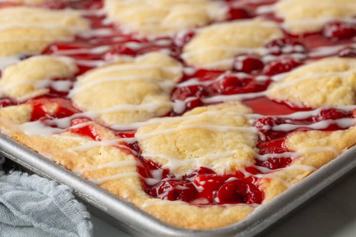 edge of a cherry coffee cake with pie filling and dollops of pastry dough.