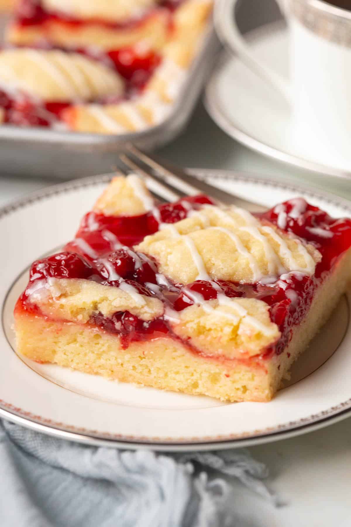 slice of cherry coffee cake on a white plate.