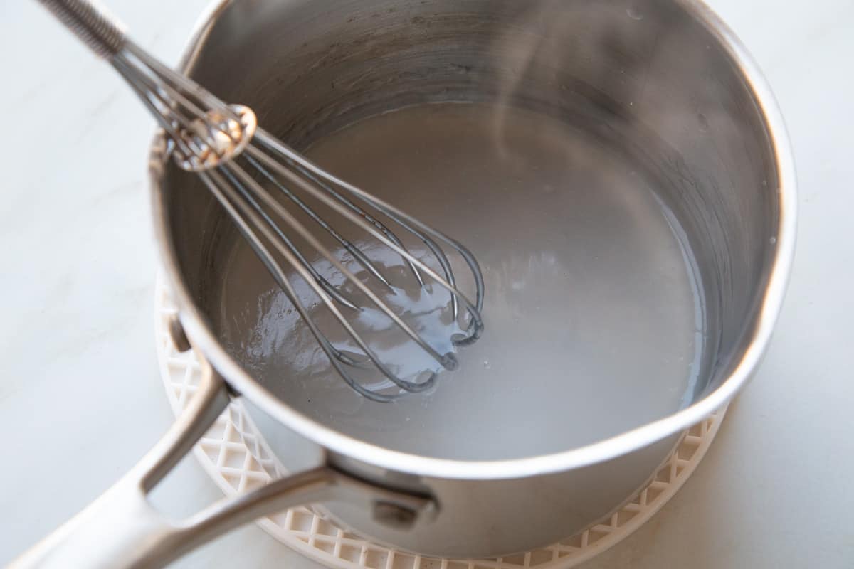 cornstarch mixture in a saucepan with a whisk.