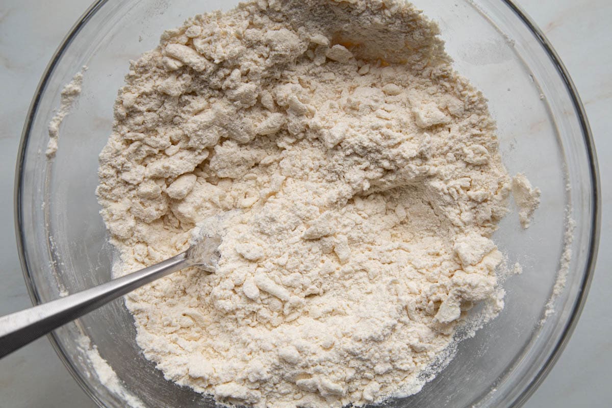 lumpy flour mixture in a glass bowl with a fork.