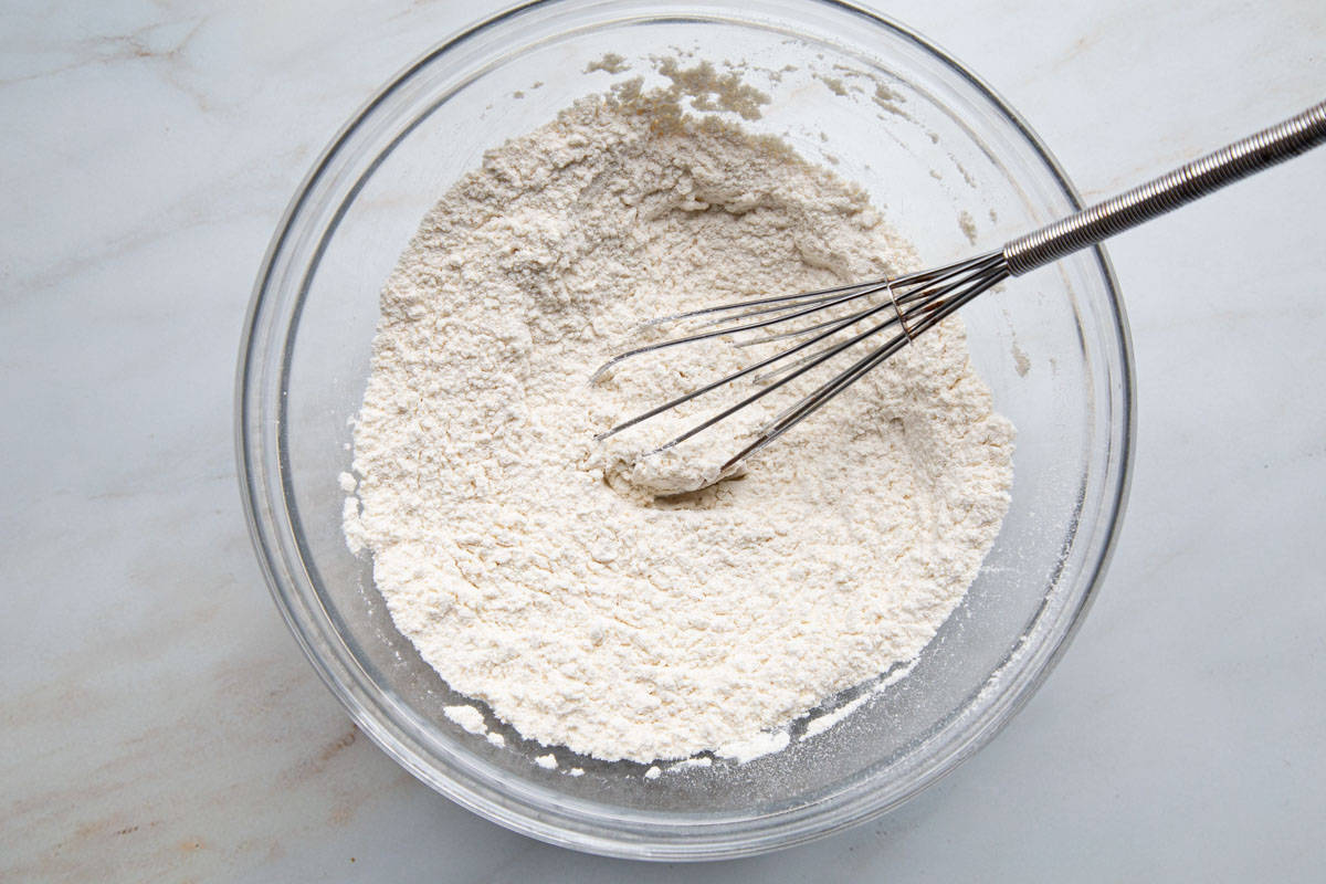 flour mixture in a glass bowl with a whisk.