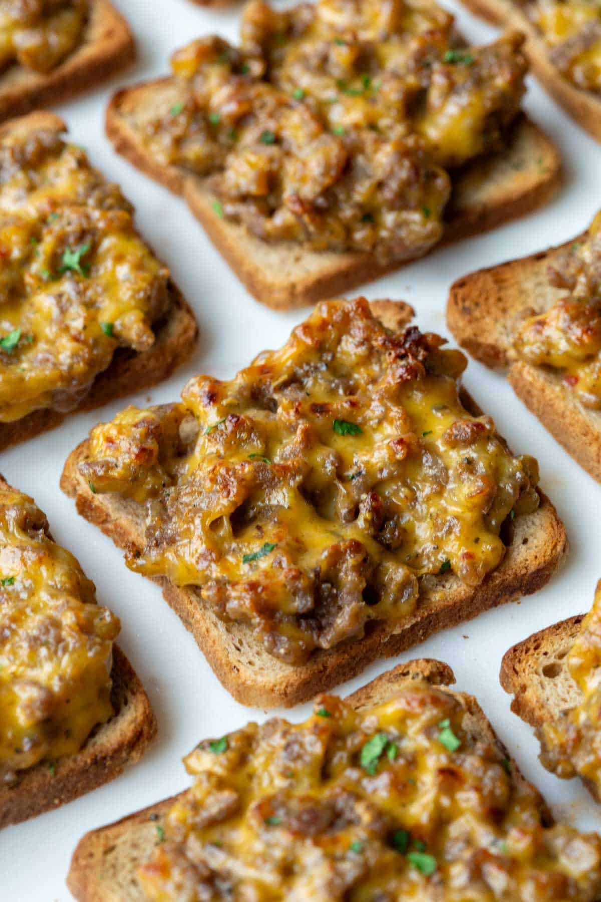 several broiled hanky panky appetizers on a white surface.