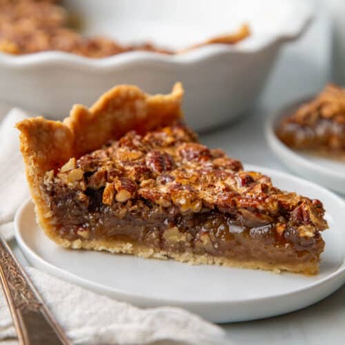 slice of old fashioned pecan pie on a white plate.