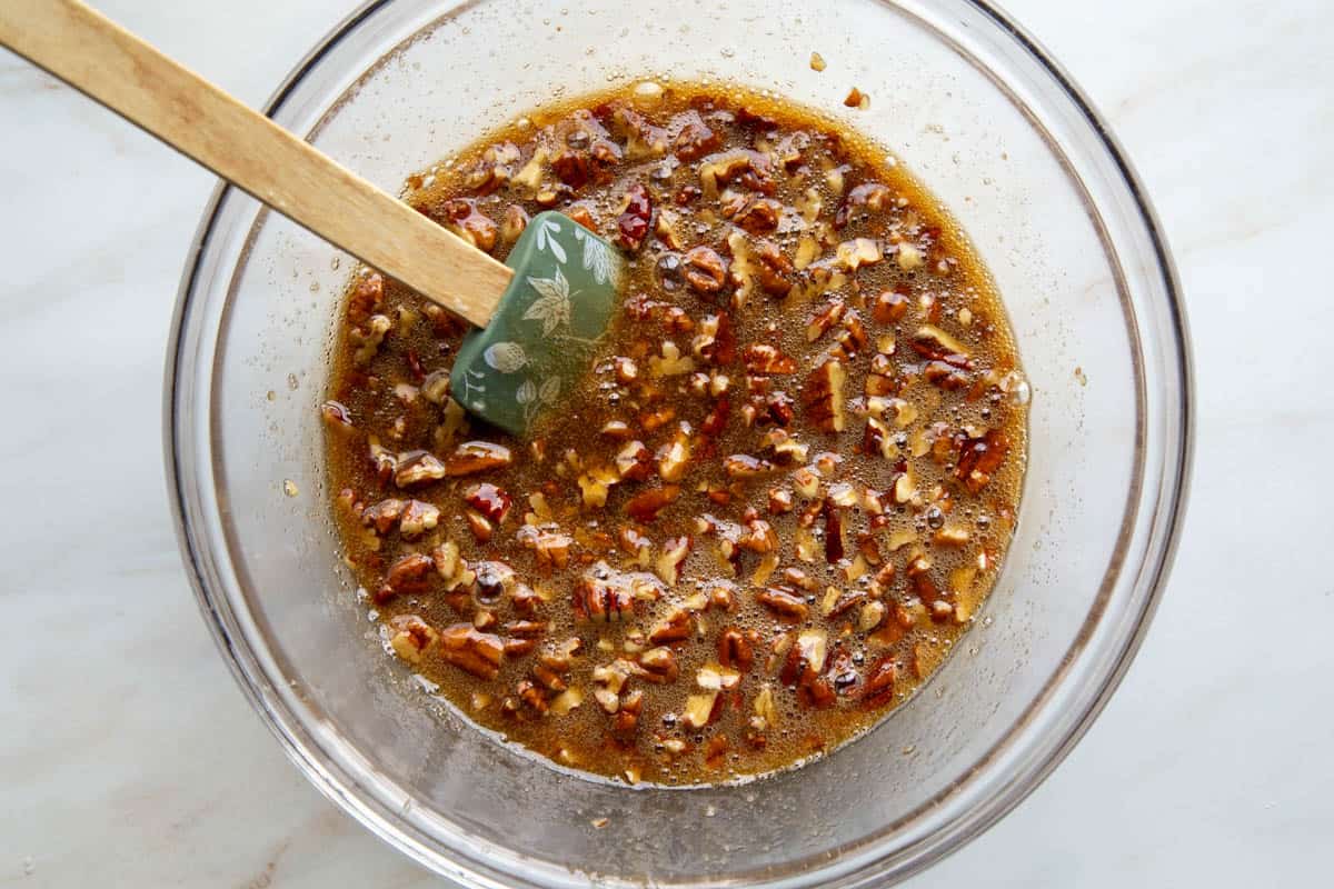 brown sugar and pecan mixture in a glass bowl with a spatula.