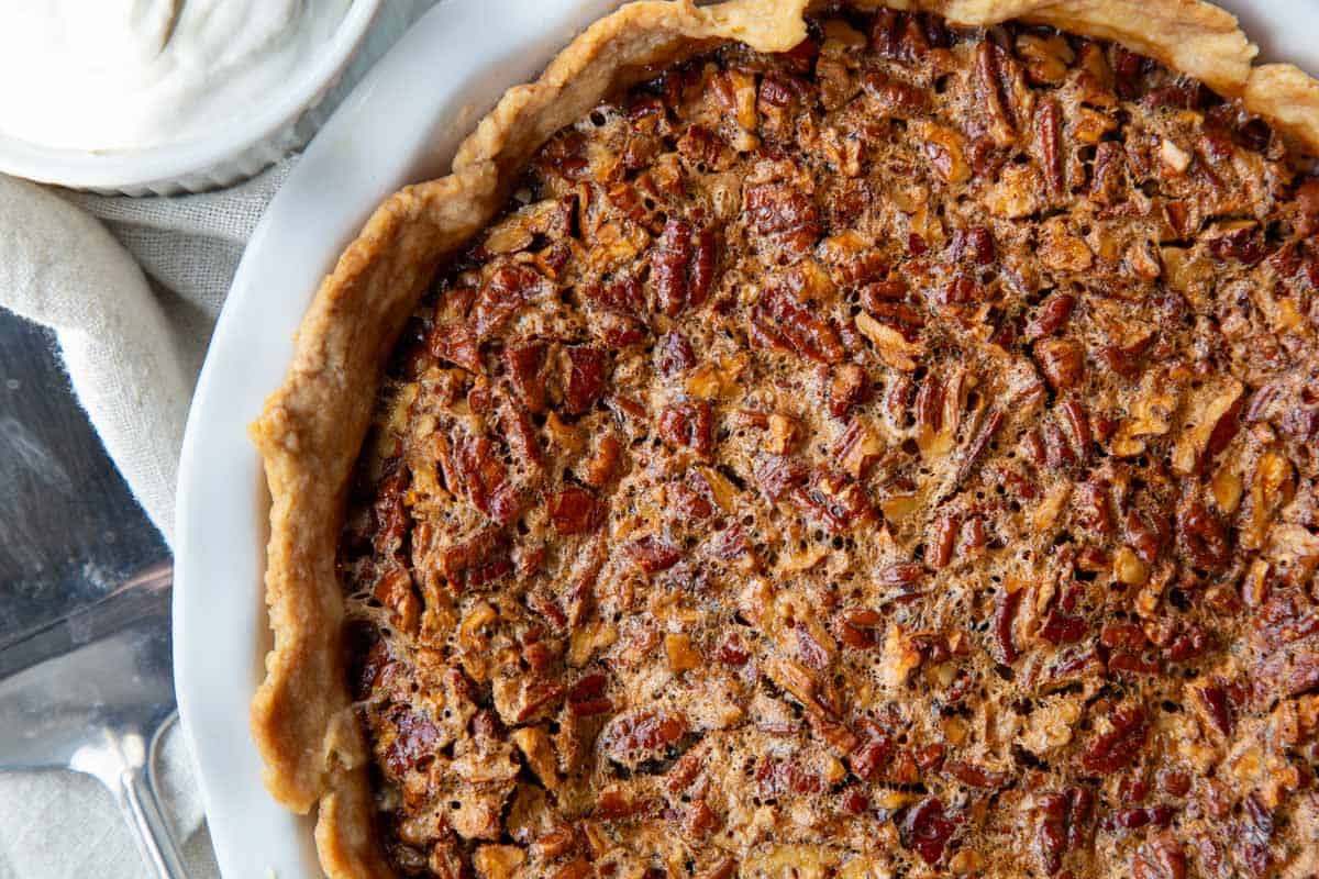 whole pecan pie in a white pie dish.