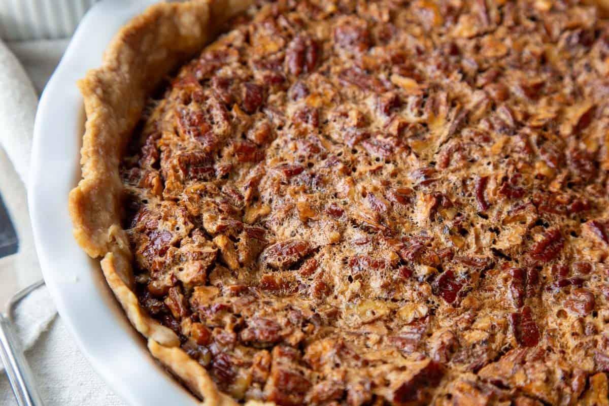 whole pecan pie in a white pie dish.