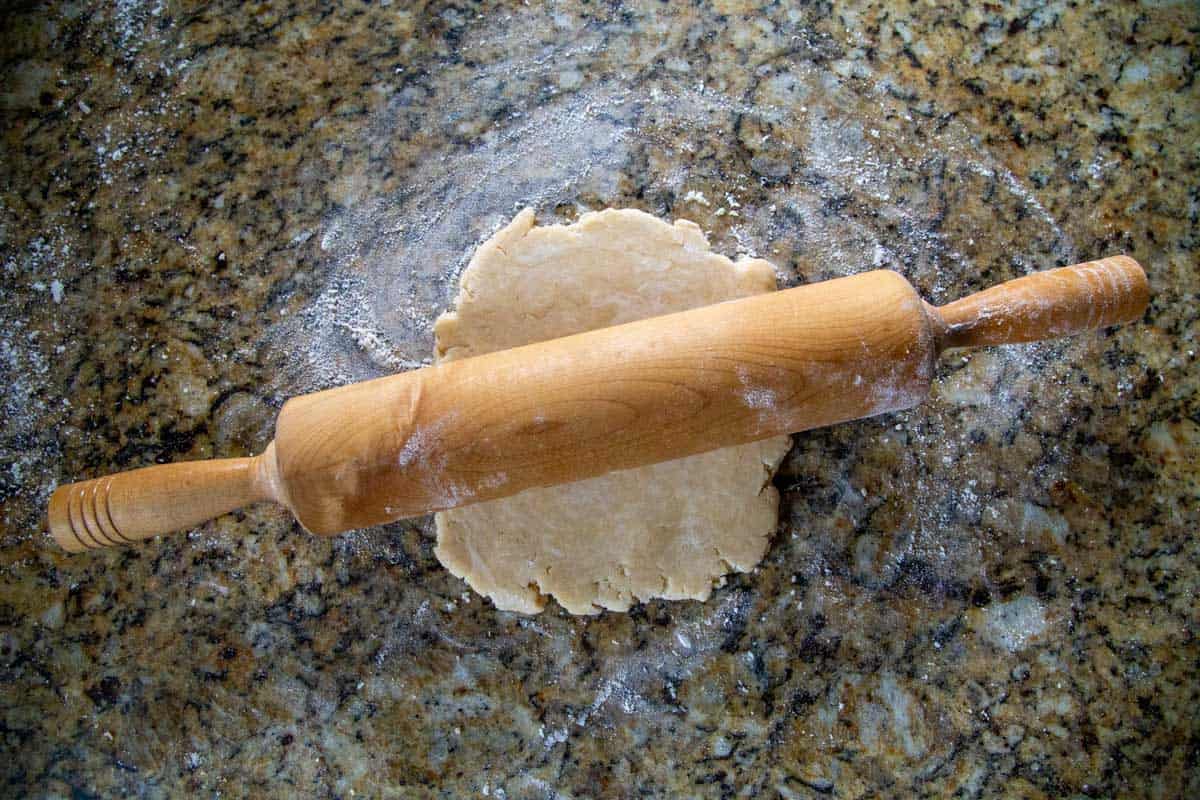 rolling pie rolling out pie dough on a countertop.