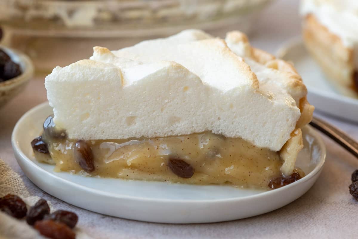 a slice of sour cream raisin pie on a small white plate.