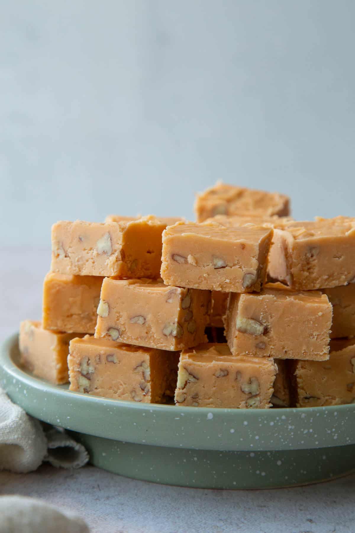 stack of butterscotch fudge on a green platter.