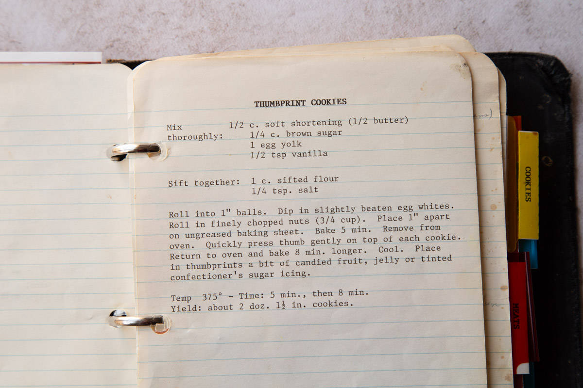 typewriter recipe for thumbprint cookies on lined paper in a black binder.