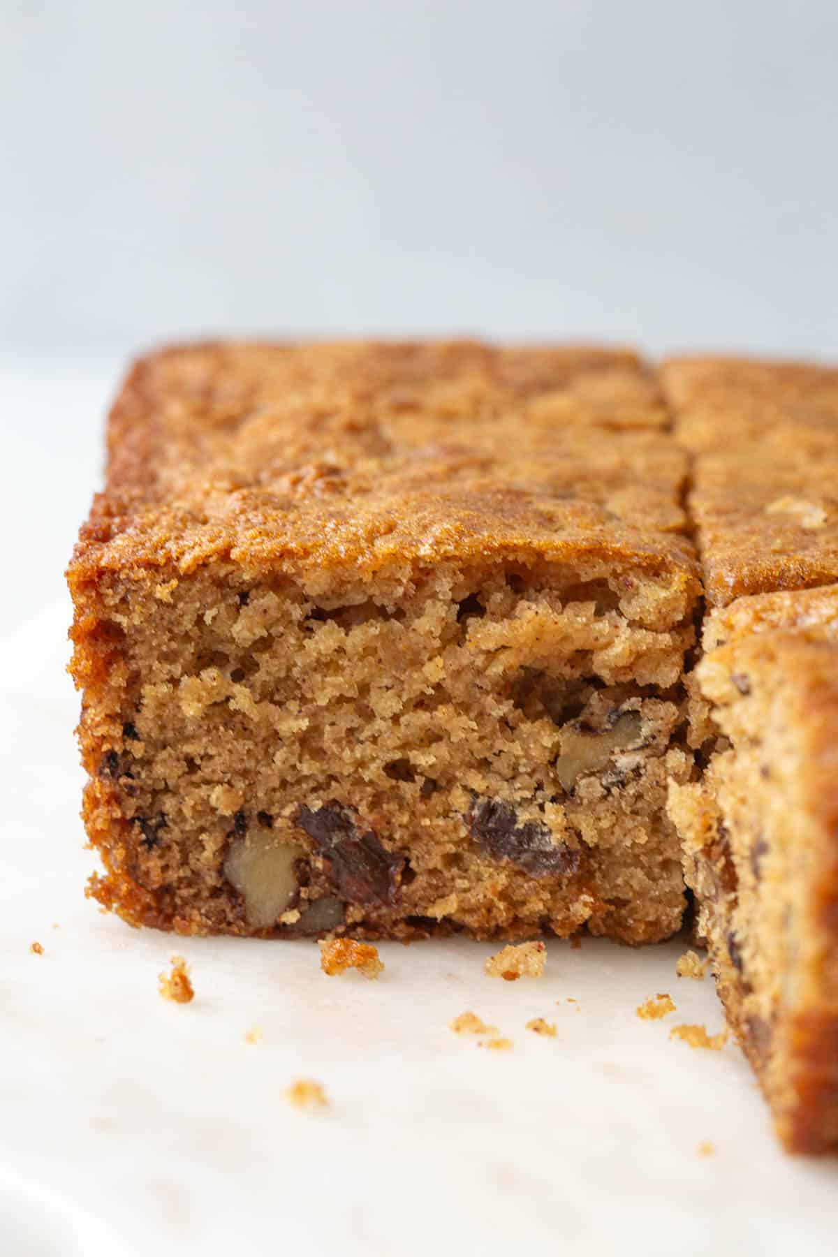 side of a piece of applesauce cake with raisins and walnuts.