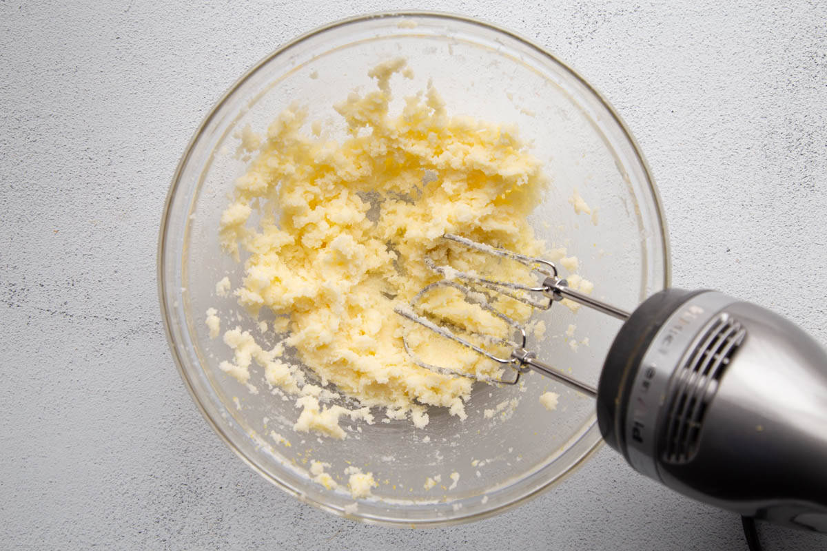 butter and sugar creamed together in a glass mixing bowl.