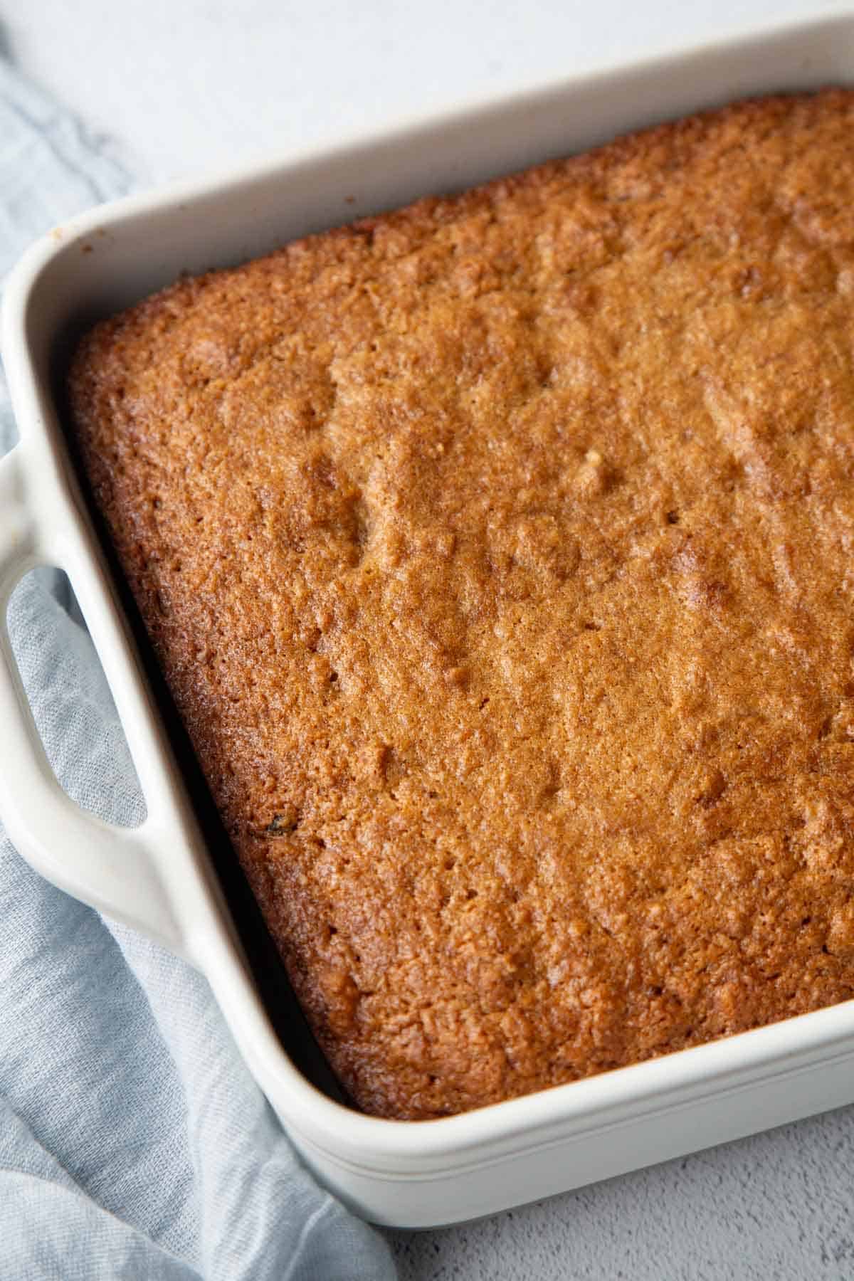 whole applesauce cake in a white square pan.