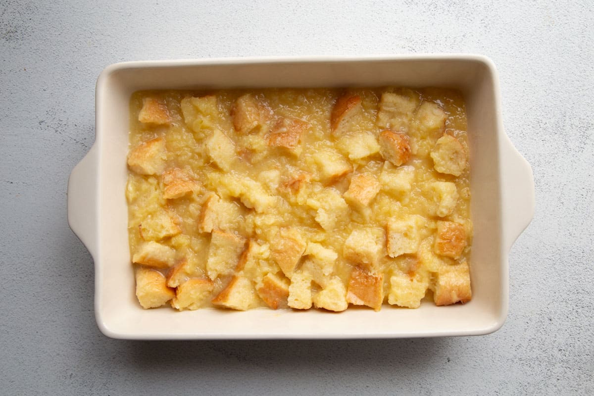 casserole dish with cubed bread in a egg and sugar mixture.