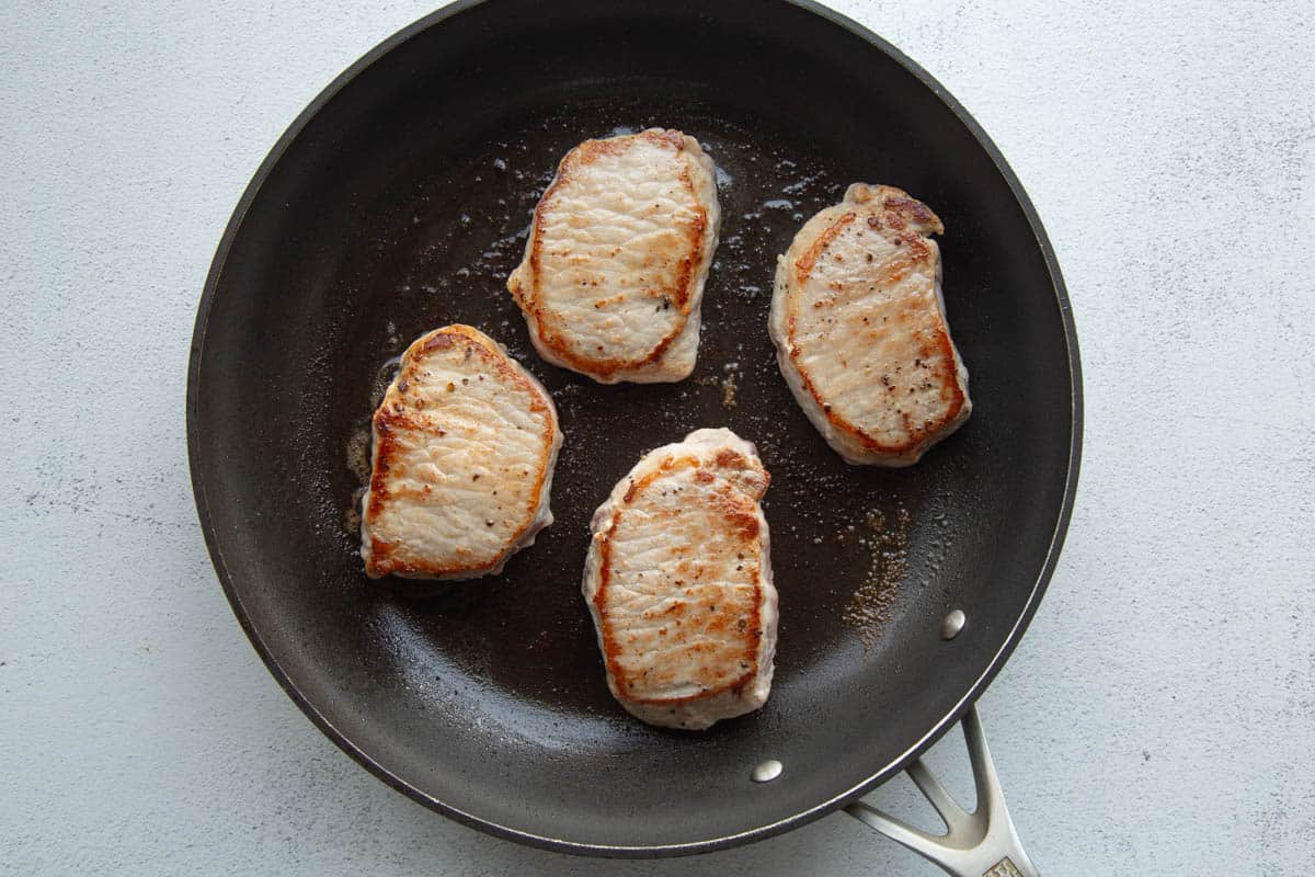 seared pork chops in a large skillet.