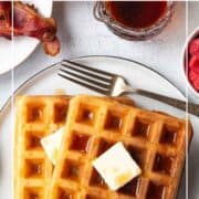 two waffles on a plate topped with butter and maple syrup.