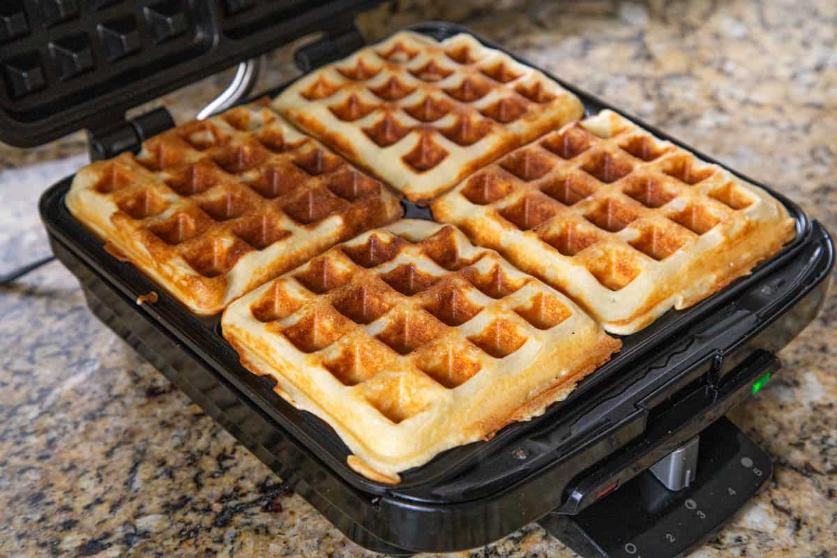 golden brown waffles on a waffle iron.